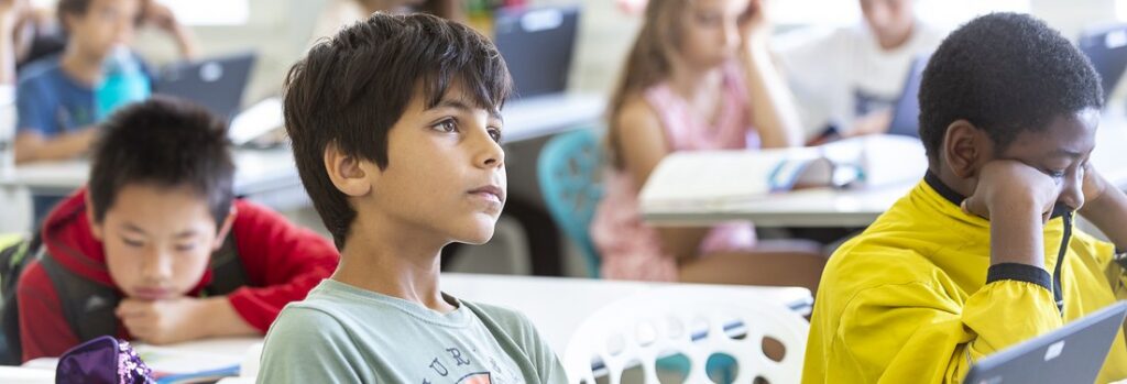 Elementary students concentrating on their work at classroom desks