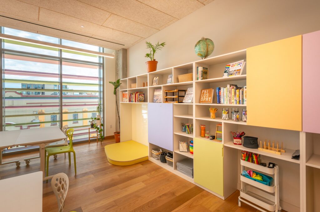 A classroom library corner with open shelving and coloured glass
