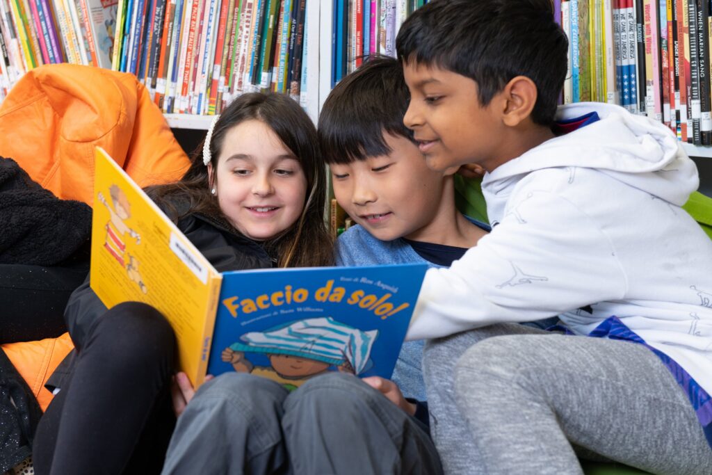 Three students reading an Italian picture book together
