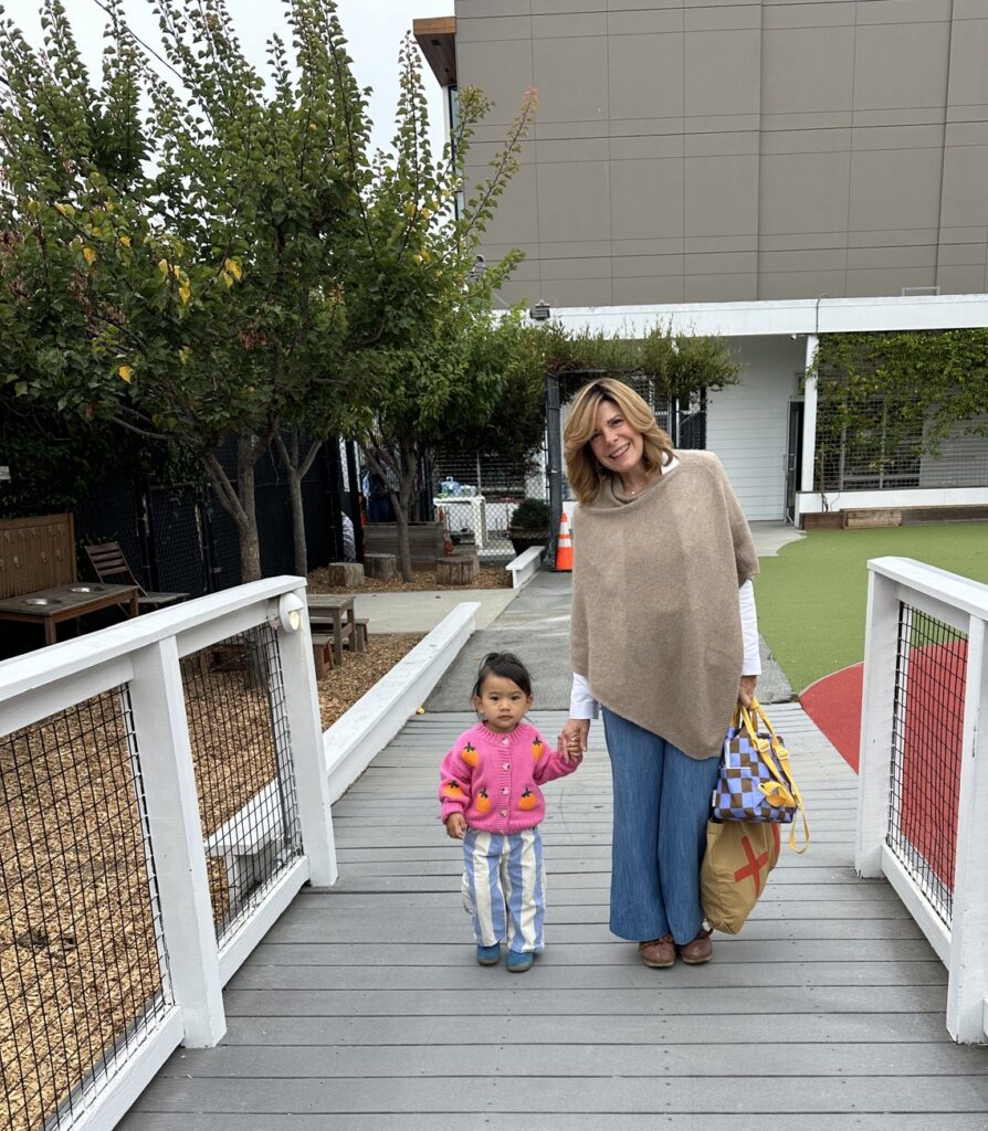 Early Childhood Director Michele Scarani walking hand in hand with a preschooler on the Dogpatch campus deck