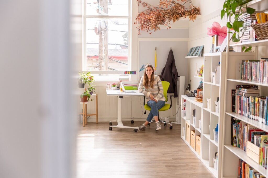 A teacher at her desk in a sunlit La Scuola classroom