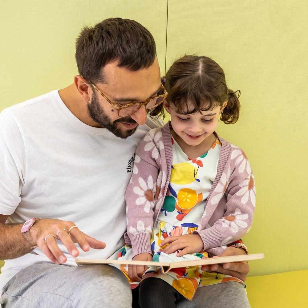 Stefano Fabro reading a picture book with a preschooler