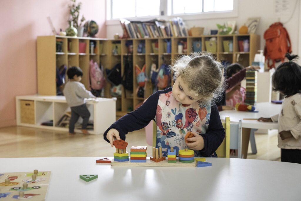 A preschooler building with blocks in a Reggio-inspired classroom